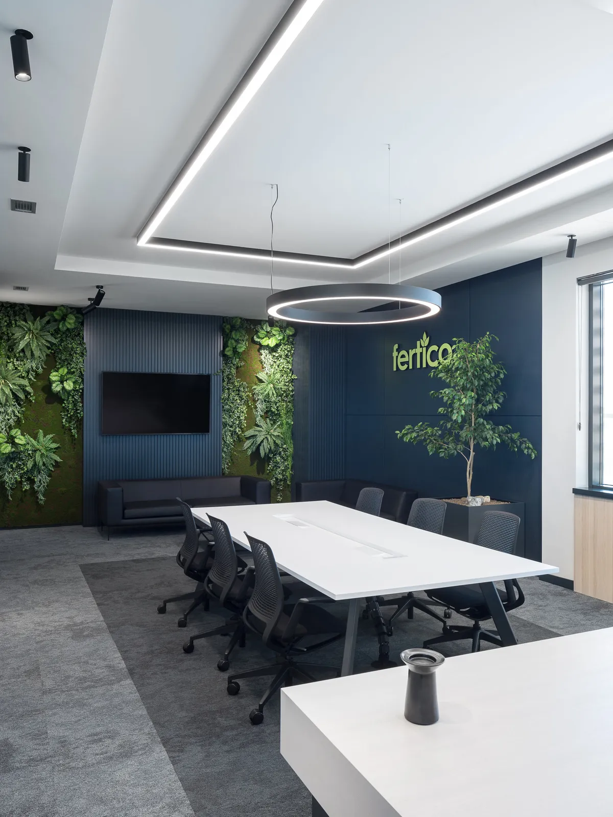 A bright conference room with lush plants on the walls, enhancing the space's natural and professional feel.