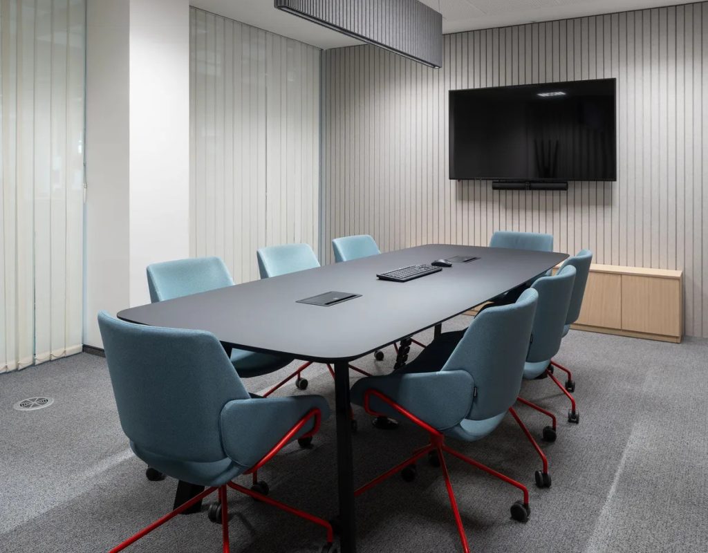A well-lit conference room showcasing a large table and several chairs for meetings.